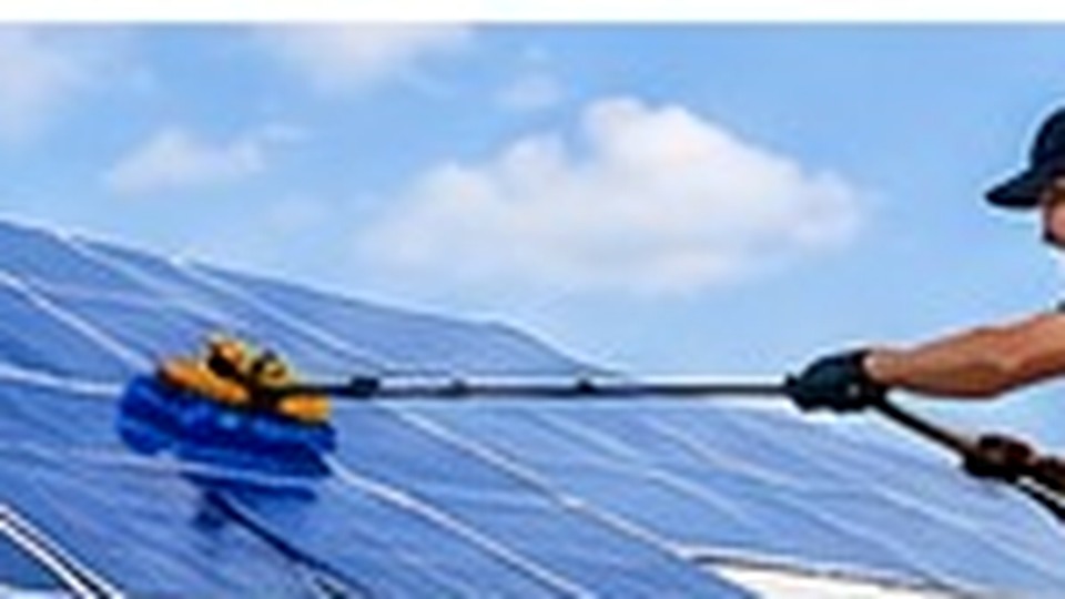 Technicien nettoyant des panneaux solaires